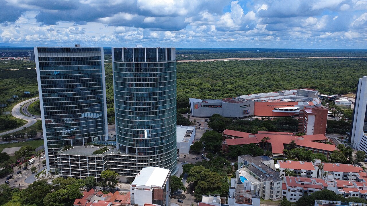 Aerial view of the Manzana 40 glass towers, Ventura Mall and red-roofed buildings among trees in Equipetrol Norte.